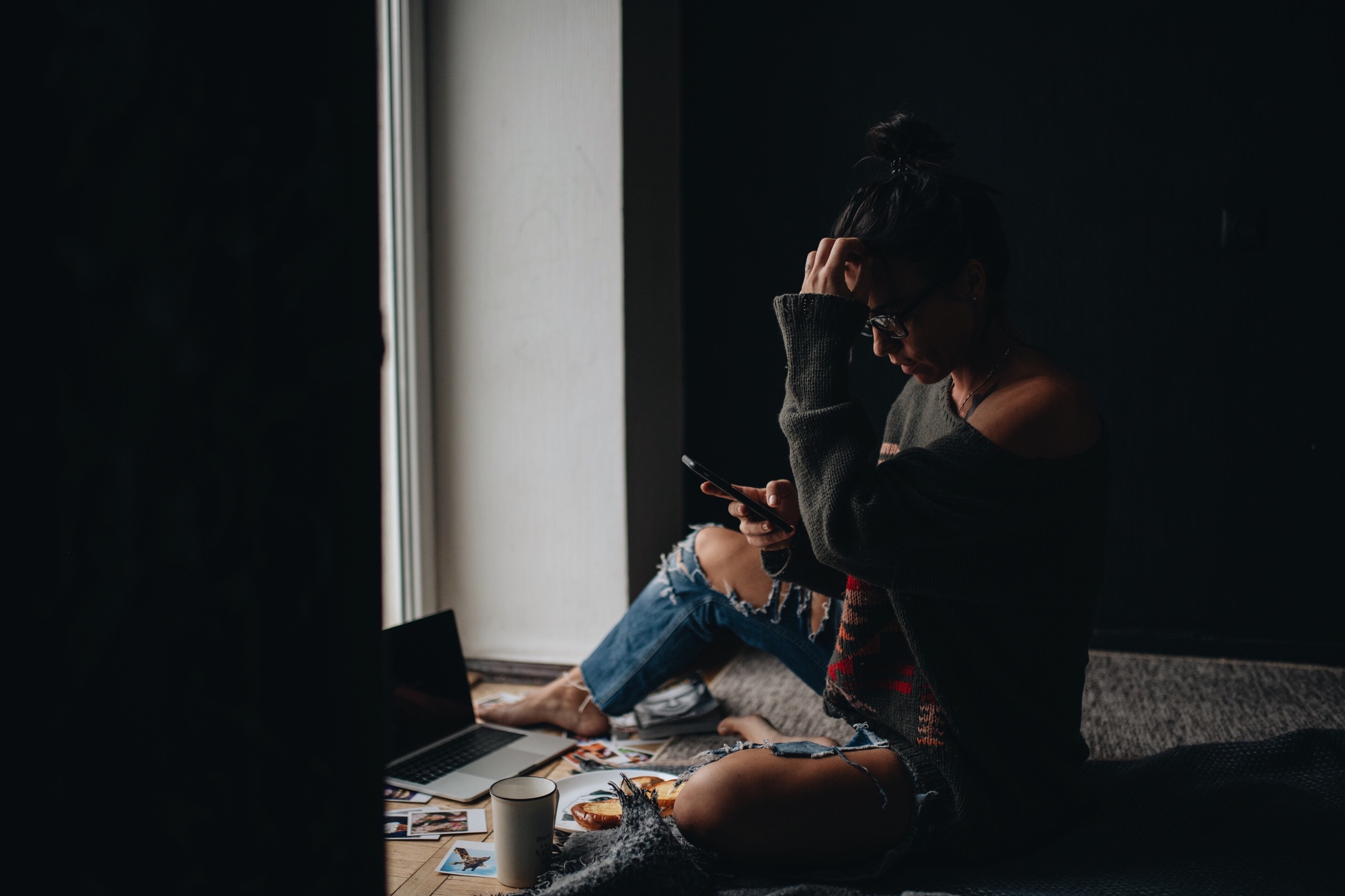 Hipster candid authentic girl using laptop and mobile device for online holiday shopping at home